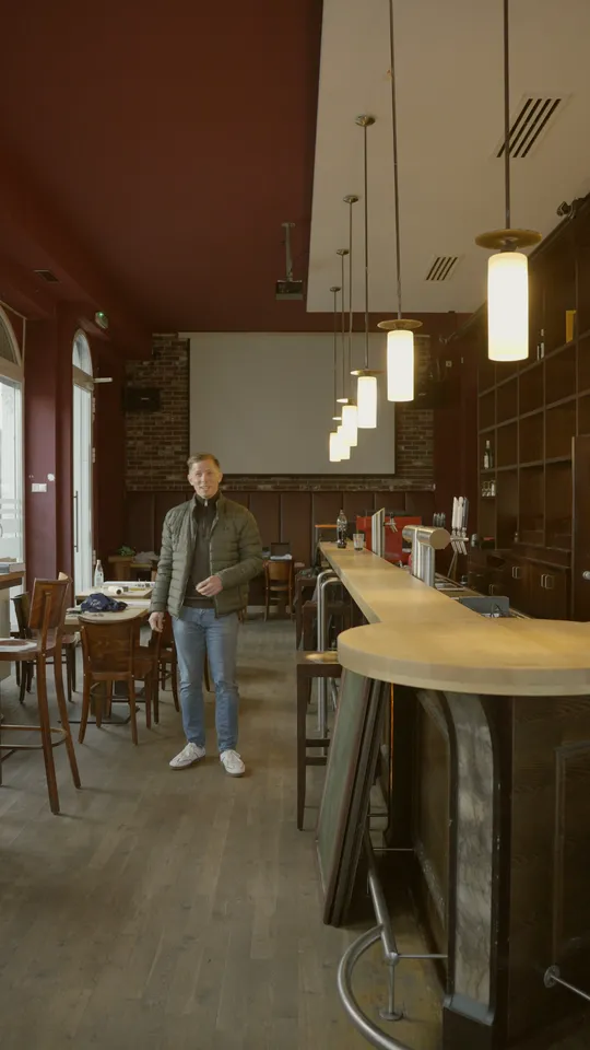 Blick durch den Gastraum zur Leinwand, rechts die geschwungene Theke