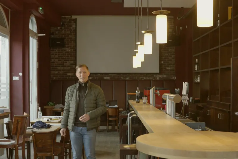 Die große Leinwand am Ende des Gastraums mit Pendelleuchten